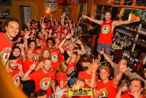 een groep mensen in rode shirts in een bar bij Sunflower Beach Backpacker Hostel in Rimini