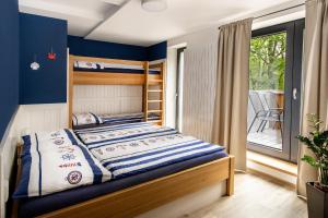 a bedroom with a bunk bed and a balcony at Penzion Labska Marina in Poděbrady