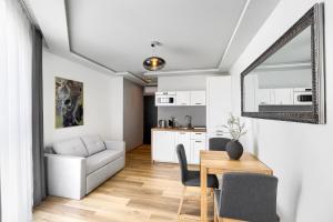 Una cocina y una sala de estar con mesa y sillas. en Toress Apartamenty Deptak, en Szczecin