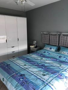 una camera con letto e piumone blu di appartement vue mer panoramique a Antibes
