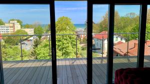 Elle comprend un balcon offrant une vue sur une terrasse en bois. dans l'établissement AQUARIUS PENTHOUSE Ustka, à Ustka