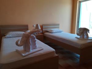 twee bedden met poppen erop in een slaapkamer bij Eleftheria's Apartments in Eratini