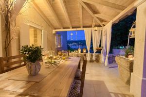 a dining room with a table on a patio at White Cottage Heritage House in Čižići +56 photos