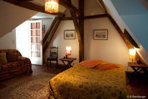 a bedroom with a bed and a couch and a window at La Demeure Saint-Ours in Loches