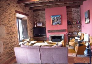 uma sala de estar com um sofá e uma lareira em Casa Rural La Torrecilla con PISCINA PRIVADA em San Pedro del Valle
