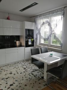 a kitchen with a table and chairs in a room at Apartament Kopernik in Wadowice