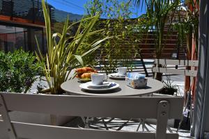 a table with two cups of coffee and a plate of food at Residence Lake Como in Colico