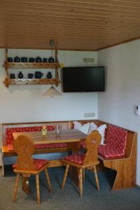 een kamer met een tafel en twee stoelen en een televisie bij Ferienwohnung Czornebohblick in Kubschütz