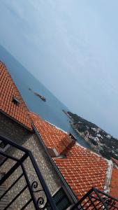 a building with an orange roof next to the water at Apartments Debora in Ulcinj