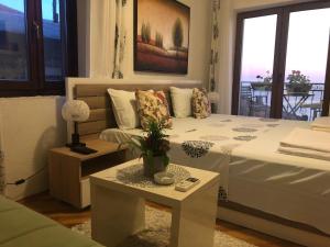 1 dormitorio con cama, mesa y ventana en Apartments Debora, en Ulcinj
