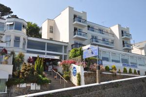 Un bâtiment blanc avec des fleurs devant lui dans l'établissement The Hannafore Point Hotel, à Looe