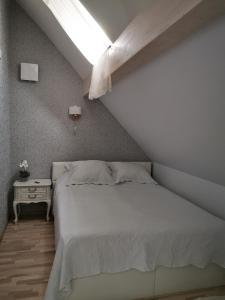 une chambre avec un lit blanc et une lucarne dans l'établissement Kuninga 24 Apartment, à Pärnu