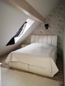 a bedroom with a white bed with a window at Kuninga 24 Apartment in Pärnu