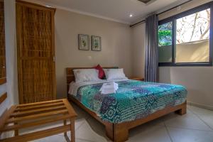 a bedroom with a bed and a window at Ossanzaia Bilene Lodge in Vila Praia Do Bilene +223 photos