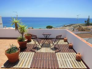 a balcony with chairs and potted plants and the ocean at IM On Luz Arte in Luz