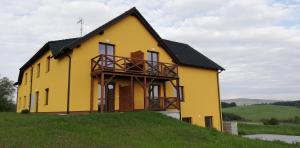 żółty dom na szczycie wzgórza w obiekcie Apartman Erika Lipno w mieście Frymburk