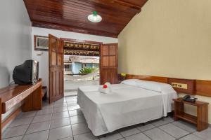 a bedroom with a bed and a tv in it at Chauã Porto Hotel in Porto Seguro