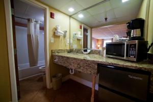 a kitchen with a microwave, sink, and refrigerator at DeSoto Beach Hotel in Tybee Island
