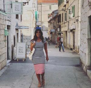 Una mujer vestida de rayas caminando por una calle en Ćiri Biri Bela Private dorm, en Split