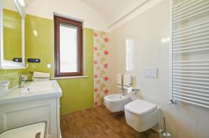 bagno con servizi igienici, lavandino e specchio di Villa Flem Luxury by HDSalento a Montesano Salentino