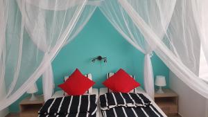 1 Schlafzimmer mit 2 Betten und roten Kissen in der Unterkunft Willa Andrus in Władysławowo
