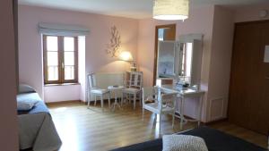 a living room with a desk and a table and chairs at Chambres d'Hôtes La Rompardais in Pléven