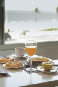 a glass of wine sitting on a table with food at Sol Ipanema Hotel in Rio de Janeiro