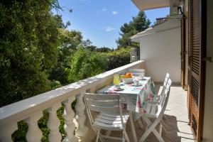 a table and chairs on the balcony of a house at Apartments Mrva in Ugljan