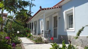 une maison blanche avec une terrasse et des fleurs dans l'établissement Armonia Houses, à Tsonia