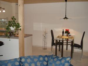 ein Esszimmer und eine Küche mit einem Tisch und Stühlen in der Unterkunft Haus am See II in Därligen
