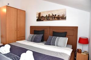 a bedroom with a bed with blue and white pillows at Apartments Martiva in Kotor +35 photos
