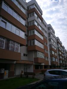 a large apartment building with a car parked in front at Apartament Karina complex Bacovia in Bacău