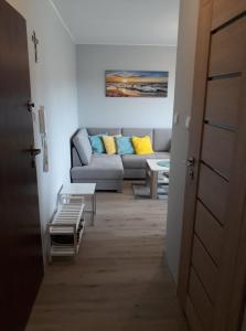 ein Wohnzimmer mit einem Sofa und einem Tisch in der Unterkunft Apartament dla Ciebie in Sztutowo