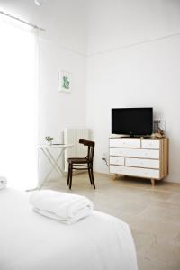 トラーニにあるLa Mitriaの白いベッドルーム(テレビ、椅子付)