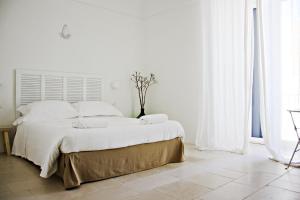 トラーニにあるLa Mitriaの白い壁の白いベッドルーム(大型ベッド1台付)