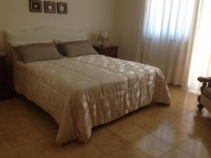 een slaapkamer met een bed met een wit dekbed bij La Gardenia in Ioppolo Giancaxio