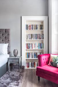 een slaapkamer met een bank en een boekenplank gevuld met boeken bij Spacious newly refurbished central apt in Edinburgh