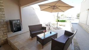 un patio con mesa, sillas y sombrilla en Apartments Lulic, en Zadar