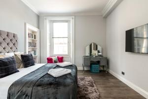 een slaapkamer met een groot bed en een televisie bij Spacious newly refurbished central apt in Edinburgh
