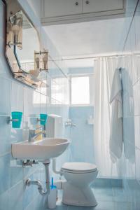Łazienka z białą toaletą i umywalką w obiekcie ILIOCHARI sea view apartments Oropos - Kalamos w mieście Kalamos