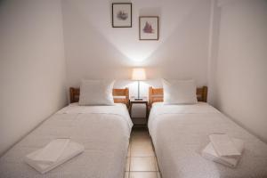 A bed or beds in a room at ILIOCHARI sea view apartments Oropos - Kalamos