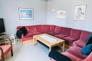 a living room with a red couch and a table at Visingsö Vandrarhem in Visingsö