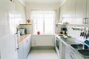 a kitchen with white cabinets and a sink and a window at Visingsö Vandrarhem in Visingsö