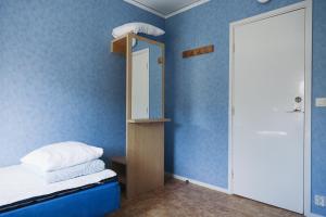 een slaapkamer met blauwe muren en een bed met een spiegel bij Visingsö Vandrarhem in Visingsö