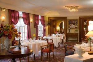 Un comedor con mesas y sillas blancas. en Hôtel Restaurant Million, en Albertville