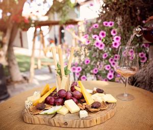 a plate of cheese and fruit on a table with a glass of wine at The Iskemleci Guest House in Lefkosa Turk