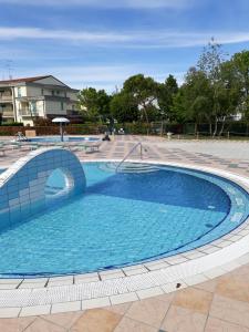 a large swimming pool in a courtyard at Appartamento Ai Tigli in Caorle
