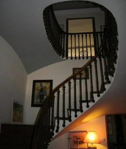 a spiral staircase in a living room with a mirror at Olmitos 3, Casa-Palacio Real Piedad in Cehegín