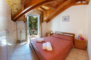 een slaapkamer met een bed met twee handdoeken erop bij Faos Luxury Apartments in Ayia Evfimia