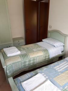 dwa łóżka siedzące obok siebie w sypialni w obiekcie Appartamento Ai Tigli w Caorle